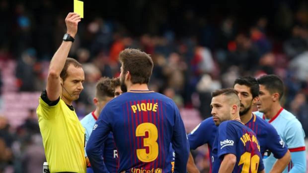 Gerard Piqué ve la tarjeta amarilla tras el pitido final del partido
