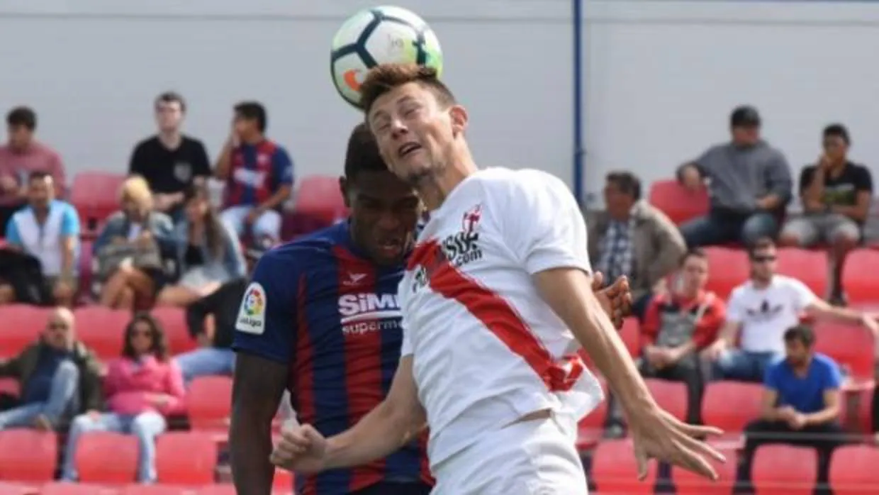 Dos rivales disputan un balón en el Sevilla Atlético-Huesca