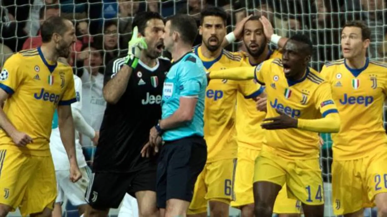 Los jugadores de la Juventus rodean a Oliver tras señalar el penalti