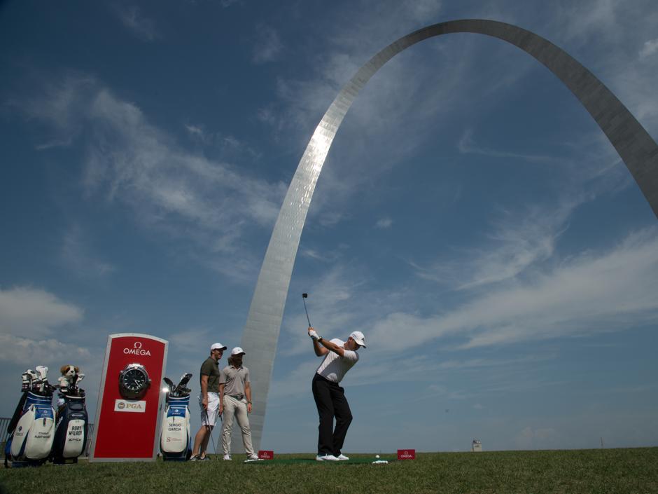 Sergio García da un golpe promocional bajo el Arco de San Luis, ante la mirada de McIlroy y Fleetwood