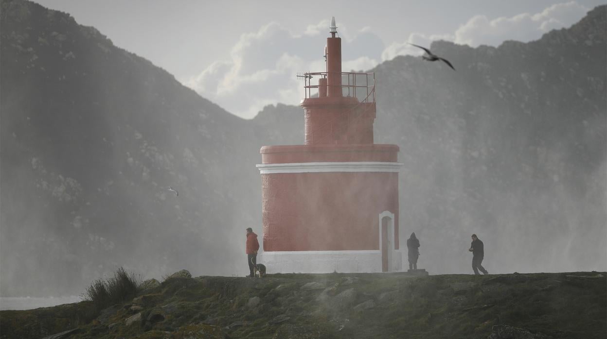 Varias personas contemplan el temporal en la baliza de Punta Robaleira (Cangas do Morrazo)