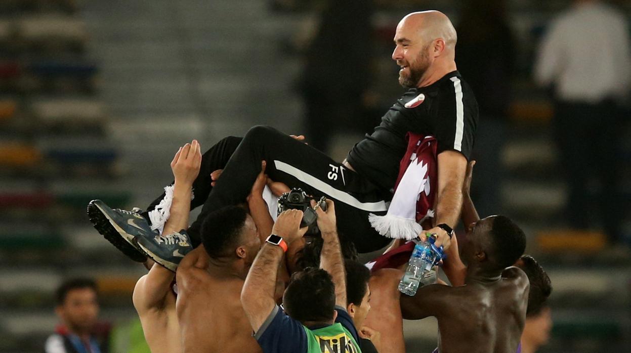 Los jugadores de Qatar mantean a su entrenador, Félix Sánchez Bas, tras conseguir la victoria ante Corea del Sur