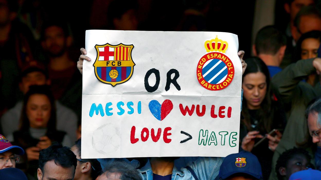 Un aficionado chino muestra una pancarta en el Camp Nou