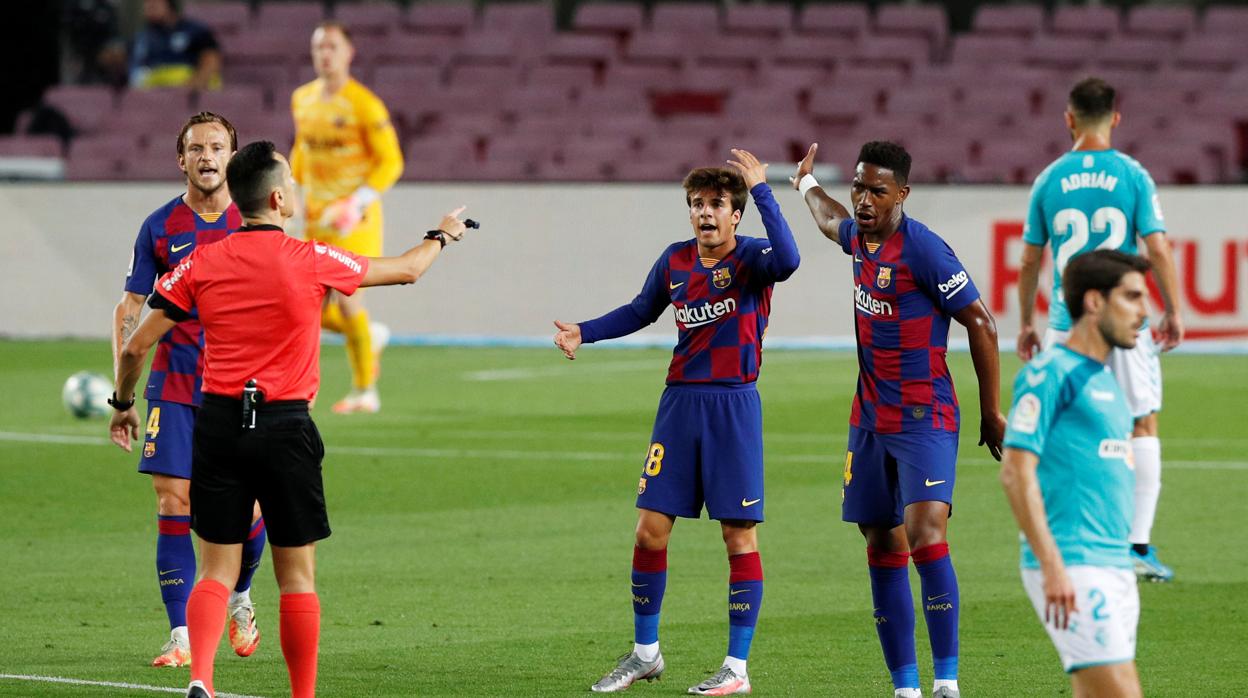 Ansu Fati y Riqui Puig se quejan al árbitro durante un partido esta temporada