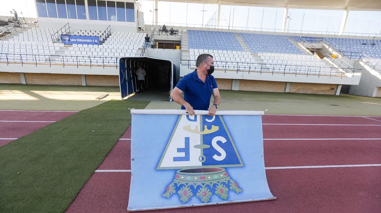 Un empleado del San Fernando retira la cartelería del estadio Iberoamericano este domingo.