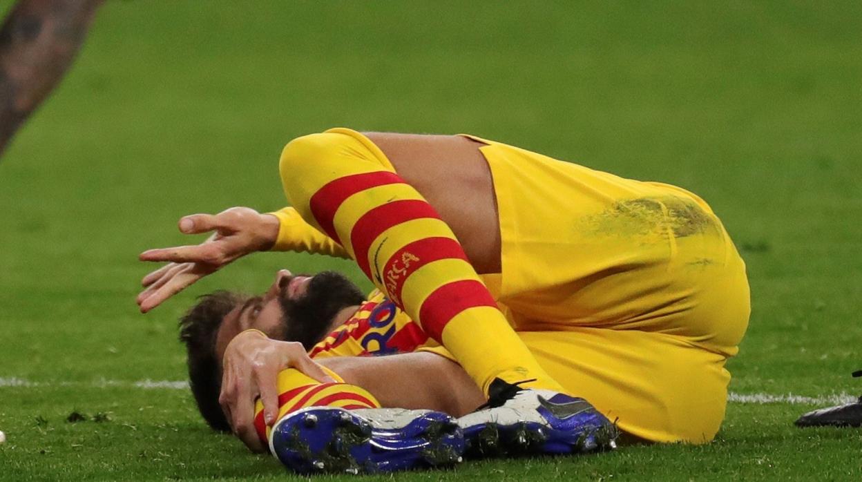 Piqué se duele en el suelo tras lesionarse en la rodilla