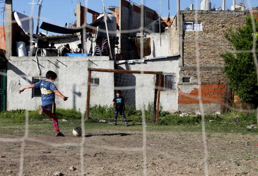 Niños jugando al fútbol en un potrero de Villa Fiorito