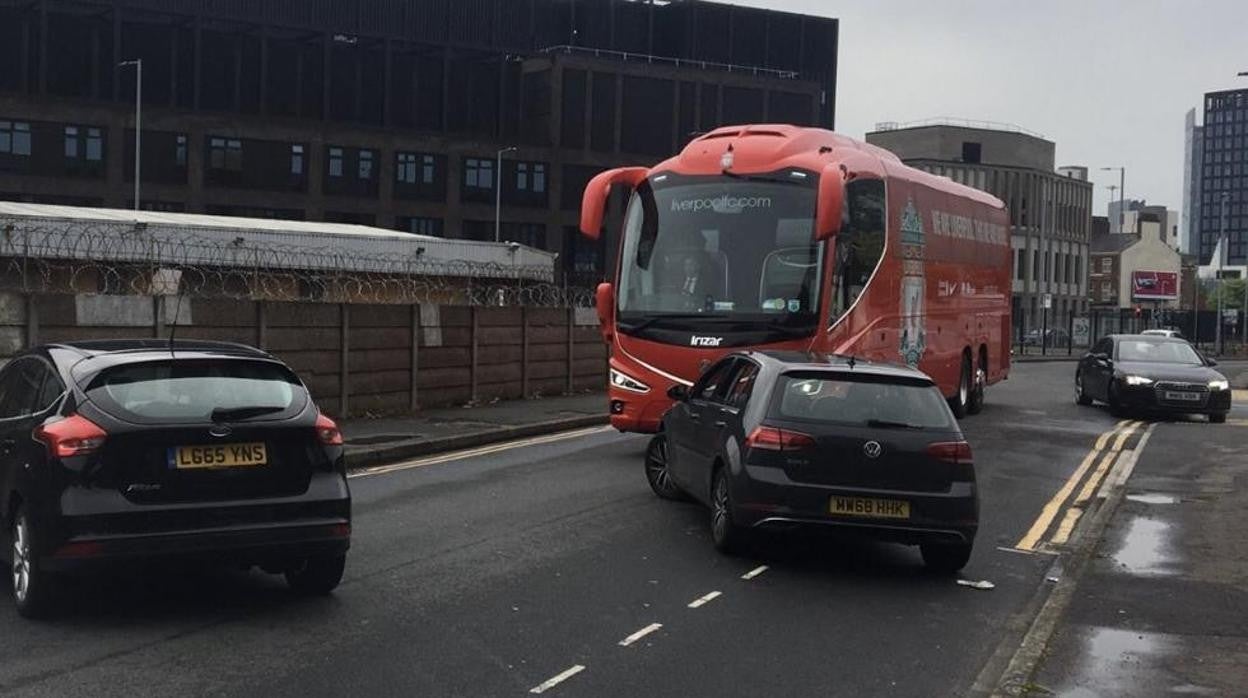 Varios coches cruzados ante el bus del Liverpool