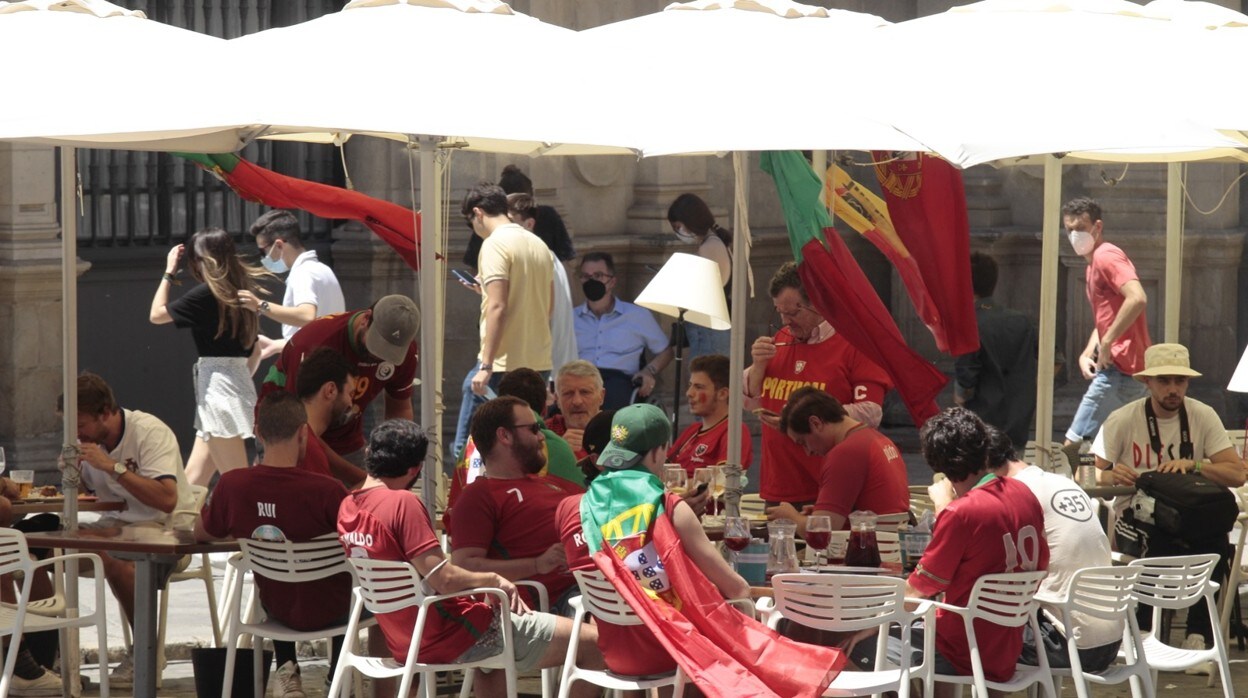 Aficionados portugueses disfrutan con una cerveza y unas tapas de la previa del encuentro de octavos de final entre la selección de Bégica y el combinado luso