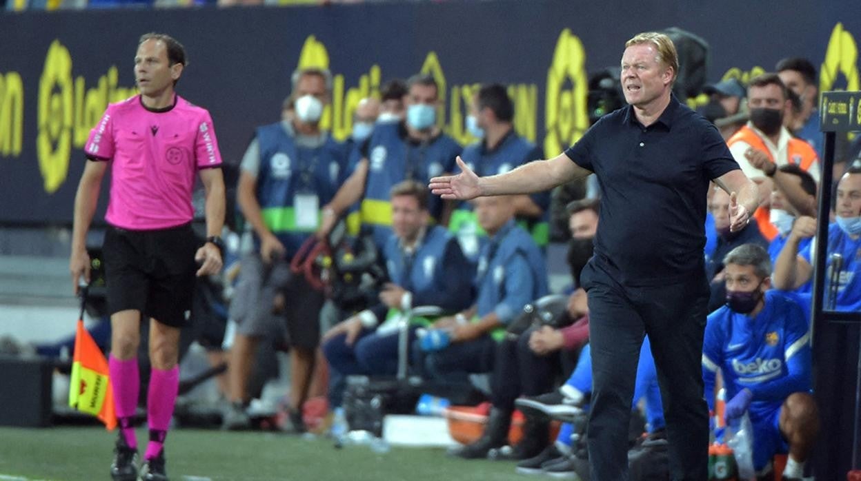 Koeman protesta una jugada ante el árbitro asistente