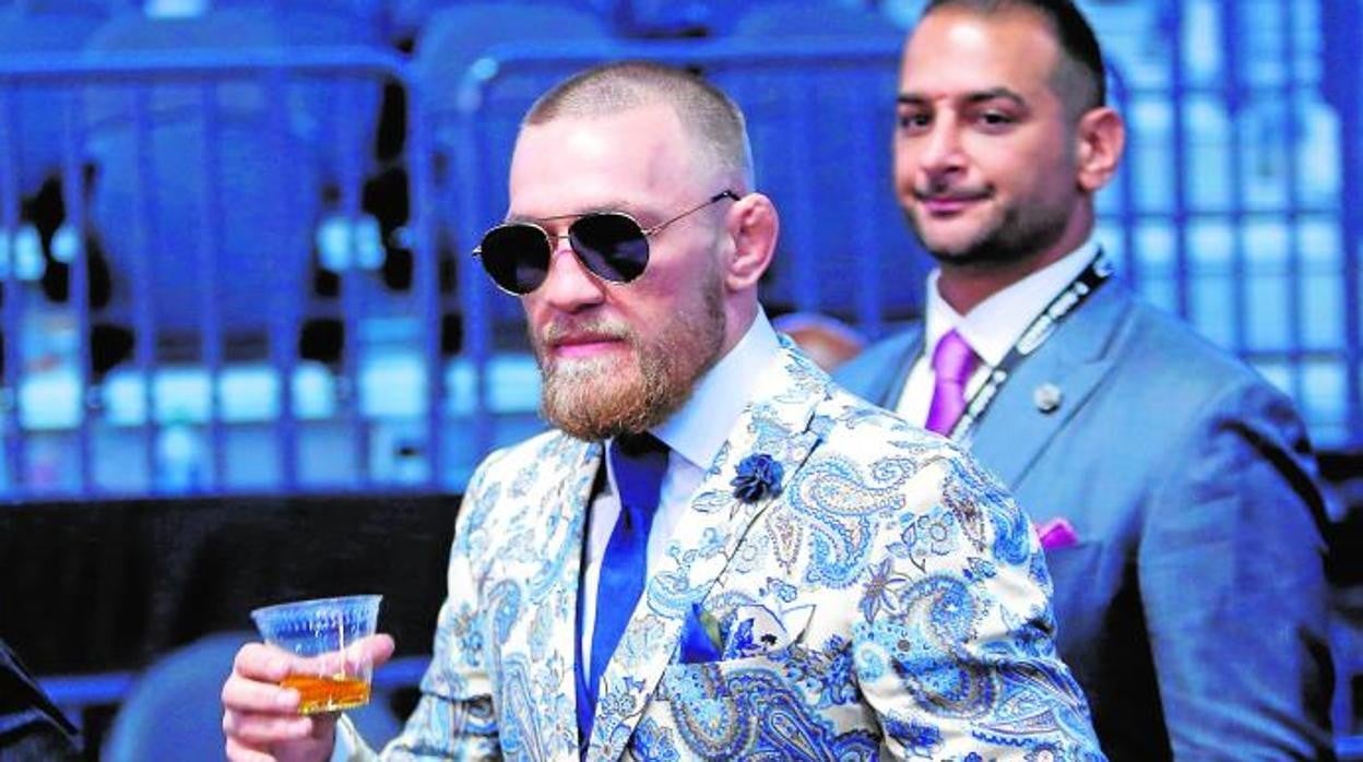 Conor McGregor, con un vaso de su güisqui, bajo la atenta mirada de su representante, Audie Attar