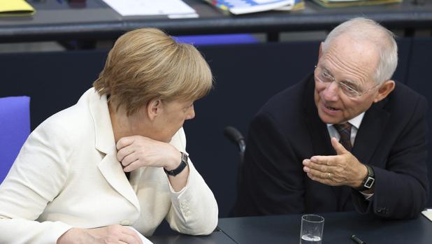 La canciller alemana, Angela Merkel (i), habla con el ministro de Finanzas alemán, Wolfgang Schäuble (d), durante un pleno del Bundestag