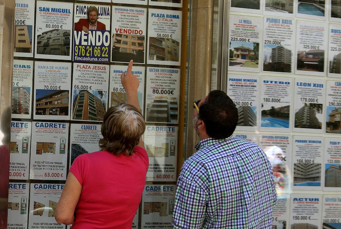 Dos personas buscando piso en una inmobiliaria de Zaragoza