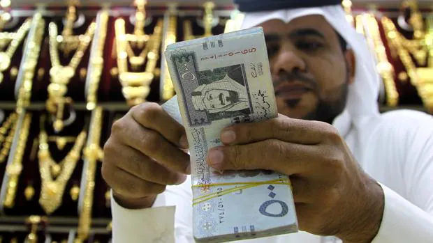 Un comerciante saudí cuenta dinero en una tienda en Riad