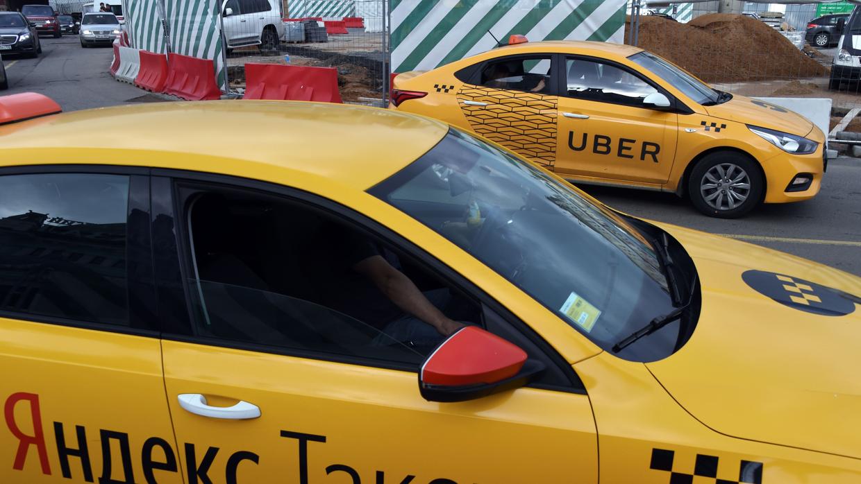 Un coche de Uber y uno de Yandez.taxi en una calle de Moscú