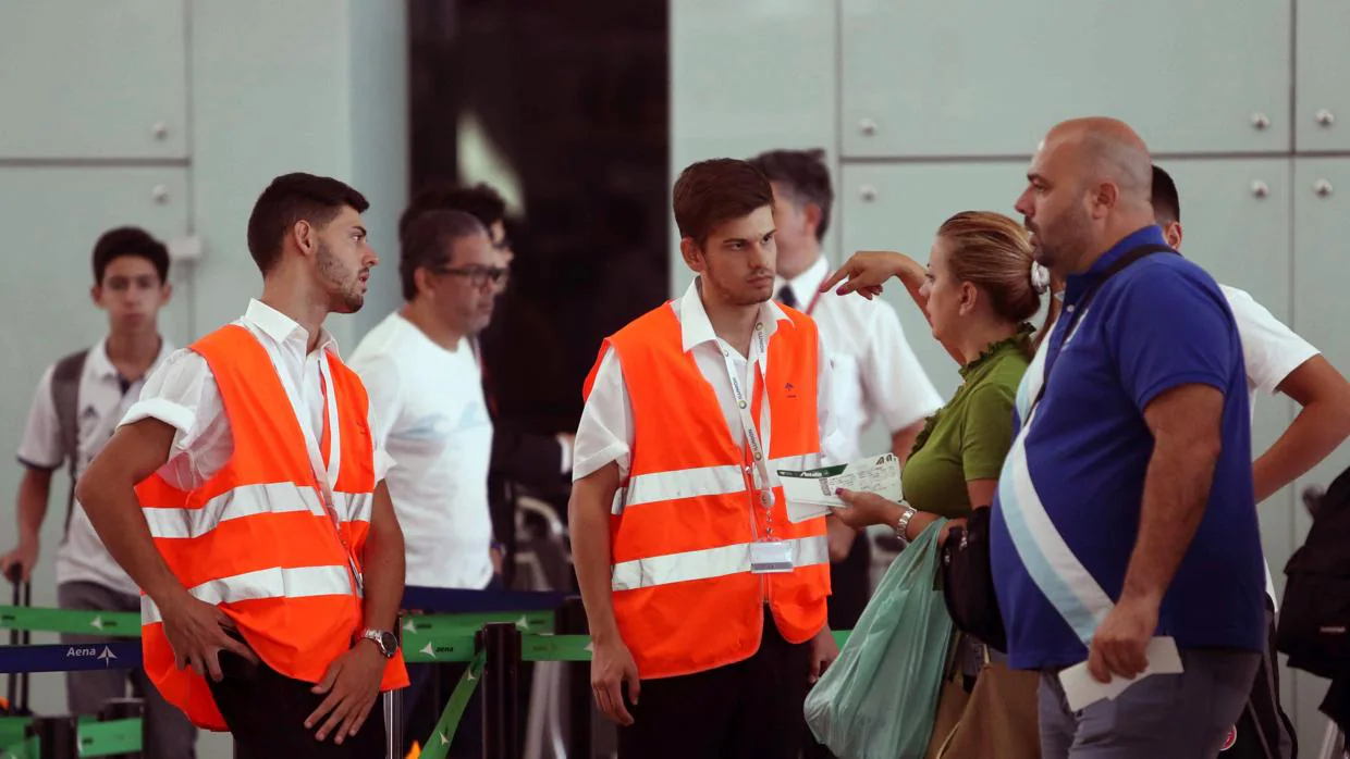 Personal de AENA informa a los viajeros en el aeropuerto de El Prat de Barcelona