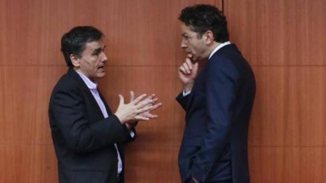 El ministro griego Tsakalotos conversa con el presidente del Eurogrupo, Disselbloem, en un receso de una reunión del Ecofin en Bruselas