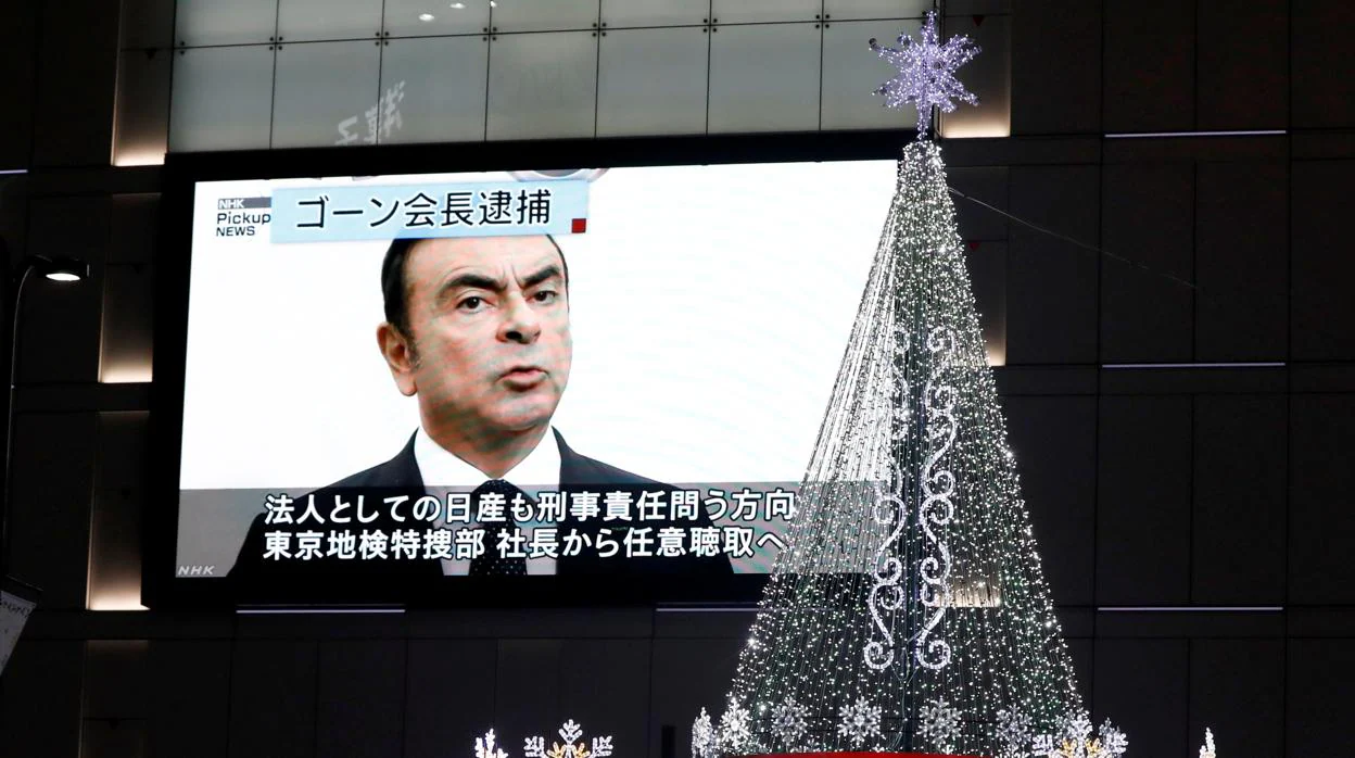 Un monitor de calle que muestra un informe de noticias sobre el arresto del presidente del grupo Renault, Carlos Ghosn, junto a las iluminaciones de Navidad en Tokio