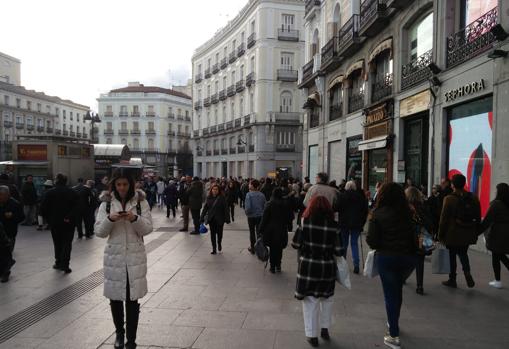 Viandantes pasean por la Puerta del Sol