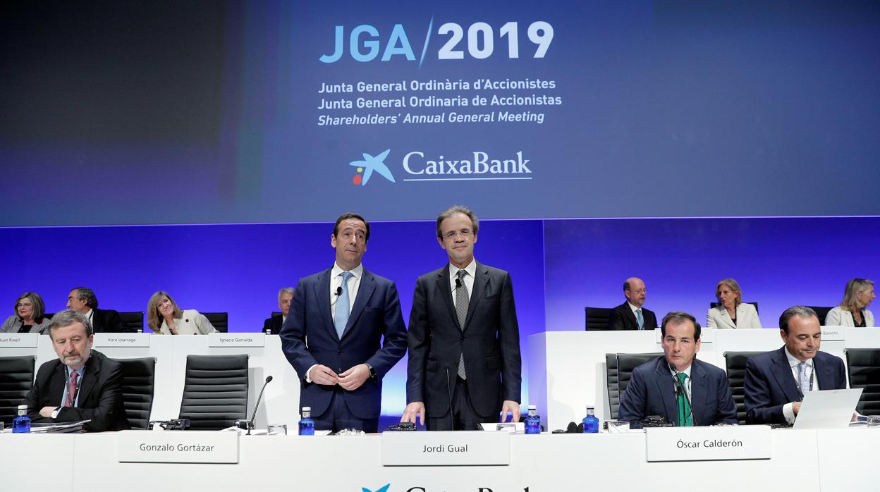 El presidente de CaixaBank, Jordi Gual (d), acompañado por el consejero delegado, Gonzalo Cortázar