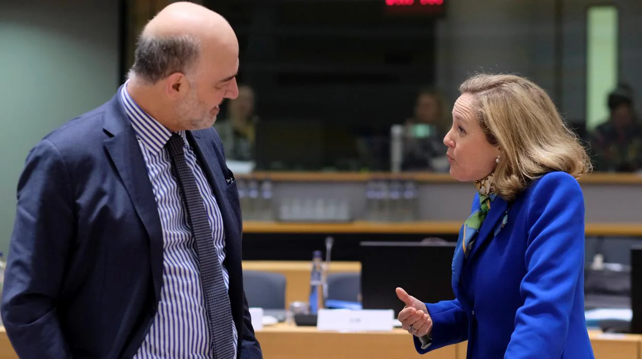 El comisario europeo de Economía y Finanzas, Pierre Moscovici (izq), conversa con la ministra de Economía española, Nadia Calviño, a su llegada a la reunión de ministros de Economía y Finanzas de la UE el pasado mes de marzo