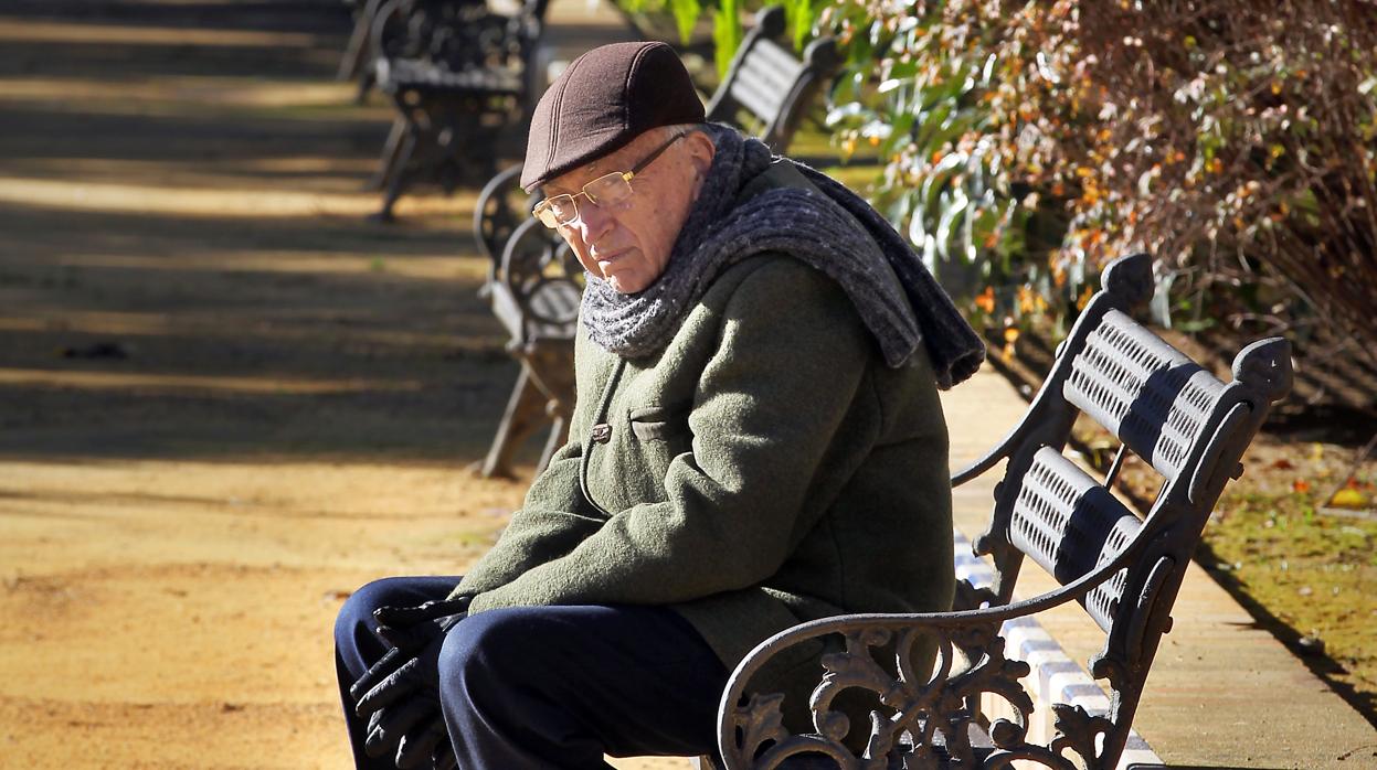 Un anciano sentado en un banco en Sevilla
