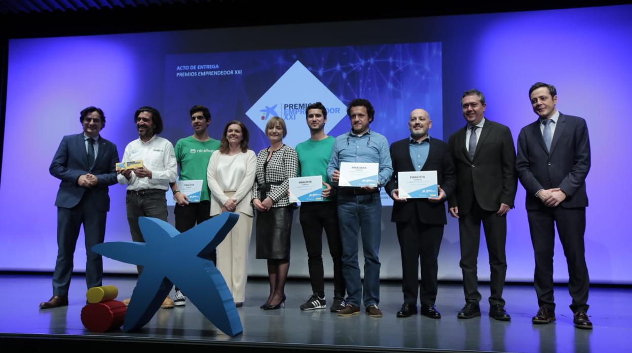 El alcalde de Sevilla y los responsables de CaixaBank, Enisa y la Junta de Andalucía, con los finalistas del Premio, en el auditorio del CaixaForum