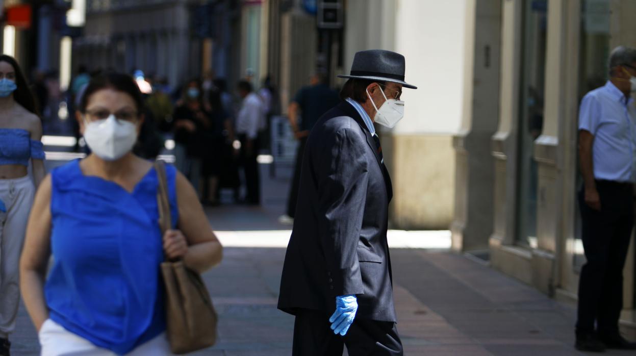 Personas con mascarillas en una calle de Málaga