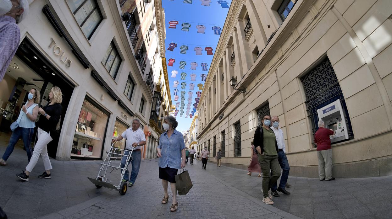 Ambiente en la calle Tetuán, decorada con camisetas del Betis y el Sevilla durante el reciente derby