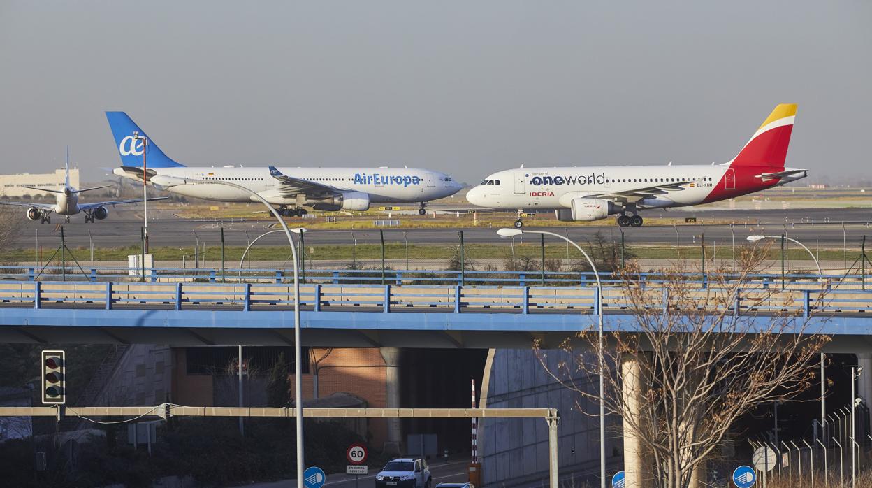 Aviones de Iberia y Air Europa por las pistas con la torre de la T4 al fondo