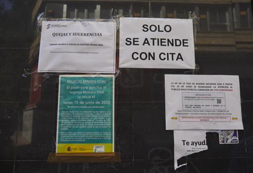 Carteles en la puerta de una oficina de la Seguridad Social en Madrid