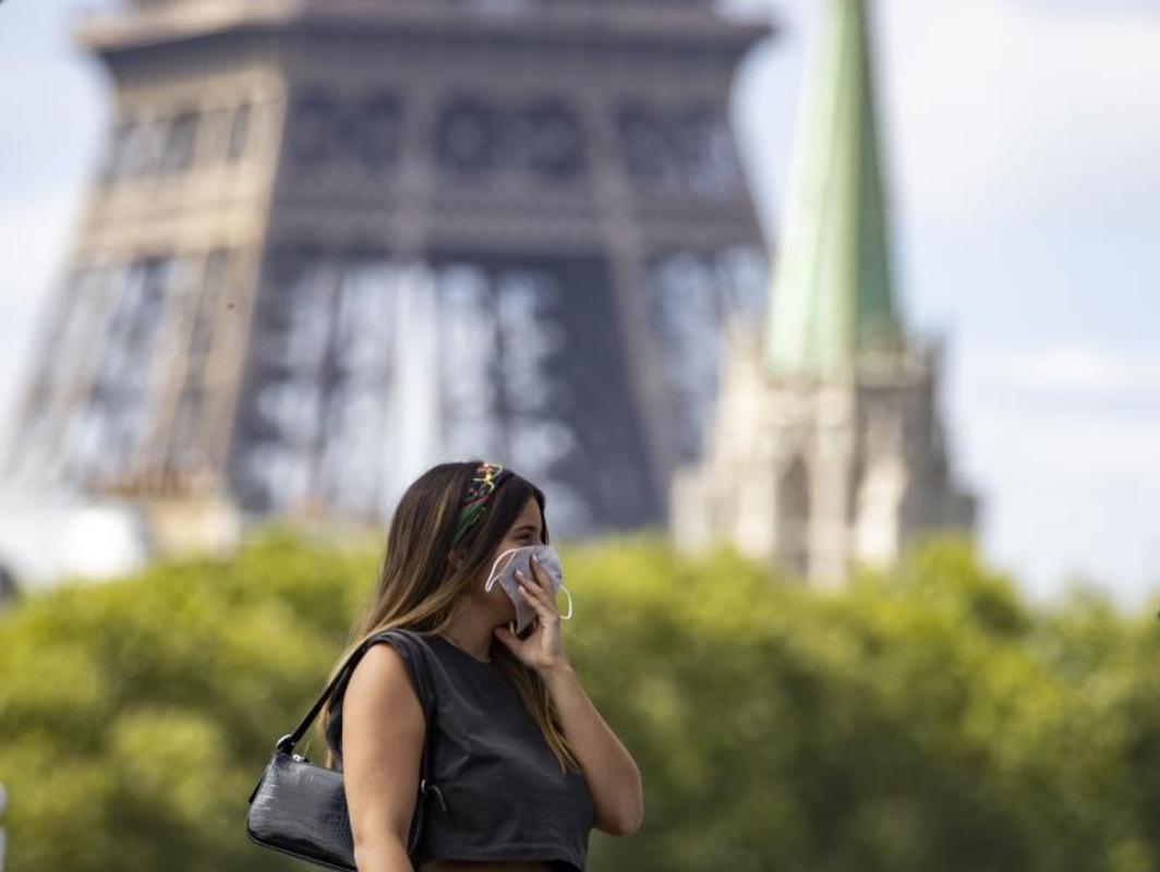 Una mujer con mascarilla pasea por París