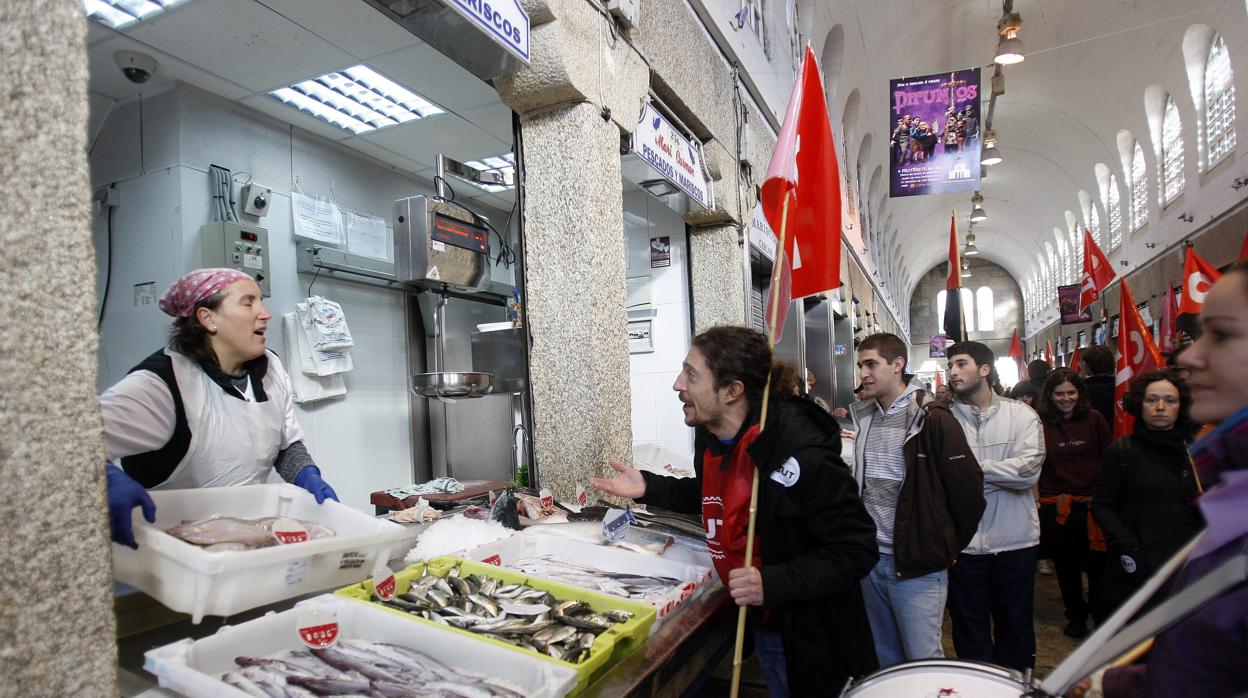 Un piquete "invita" a una pescadera a cerrar en Santiago durante la huelga general de 2012