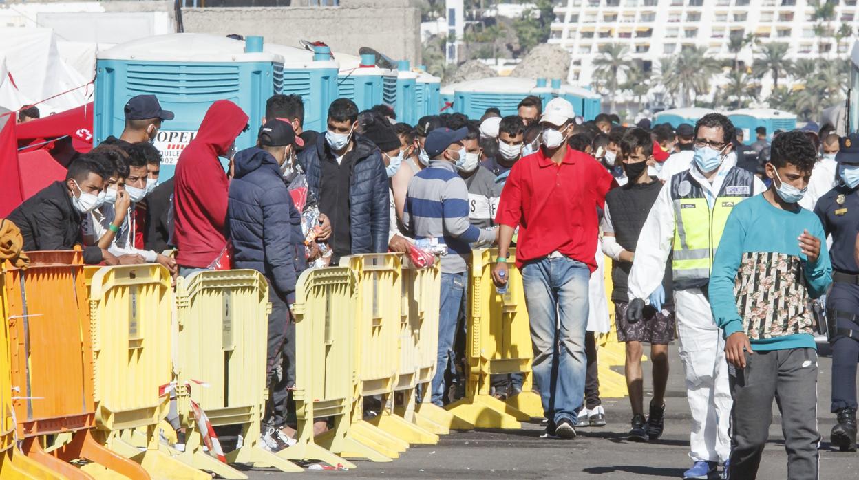 Varios inmigrantes hacen cola en el Muelle de Arguineguín, en Gran Canaria