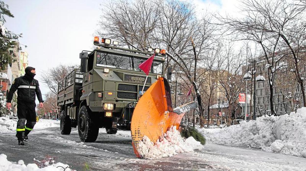 Miembros de la a Unidad Militar de Emergencias (UME) ayudados de una máquina quitanieves trabajan retirando nieve en el Paseo de la Castellana