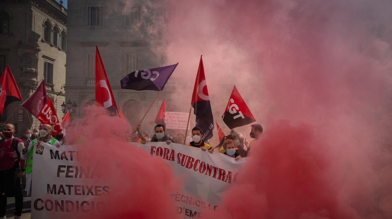 Varias personas encienden bengalas como signo de protesta en la plaza Sant Jaume durante una jornada de huelga general de la sanidad pública y privada, en Barcelona,