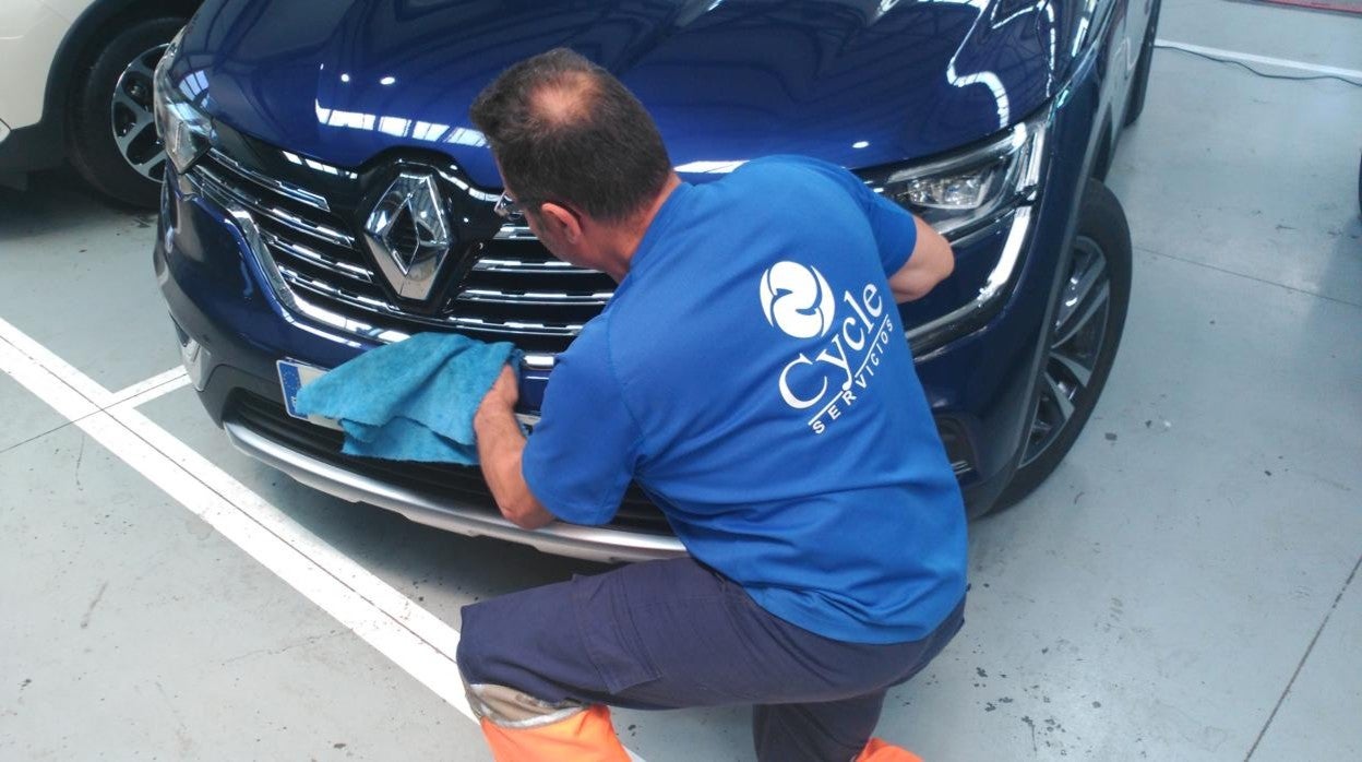 Un trabajador de Cycle presta un servicio de limpieza en un concesionario de coches