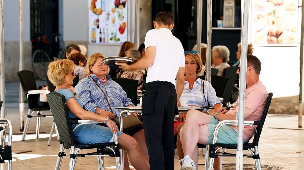 Un camarero sirviendo a unos clientes en Valencia