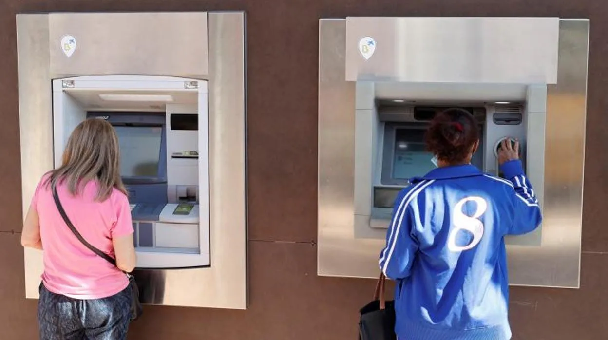 Dos ciudadanas sacan dinero de los cajeros de una entidad bancaria en Madrid