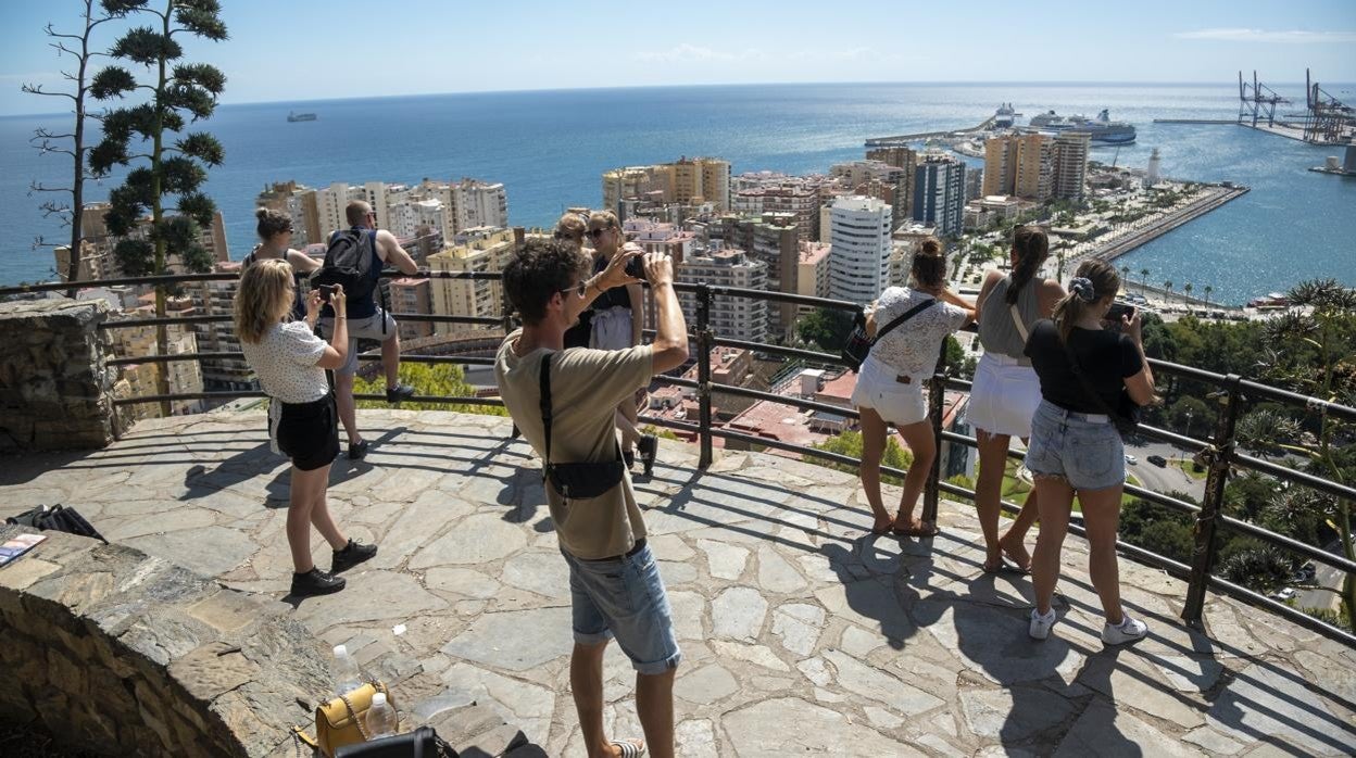 Turistas avistan la llegada de cruceros en el puerto de Málaga