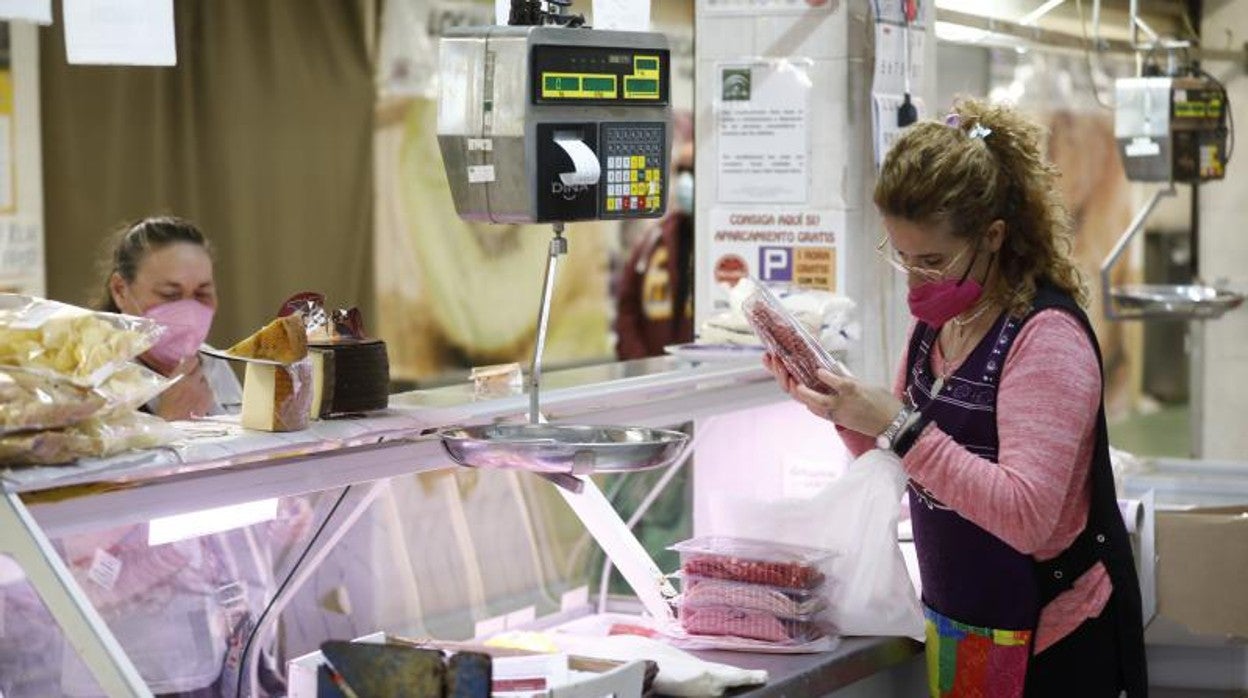 Una carnicera consulta un precio en un mercado de abastos en Córdoba