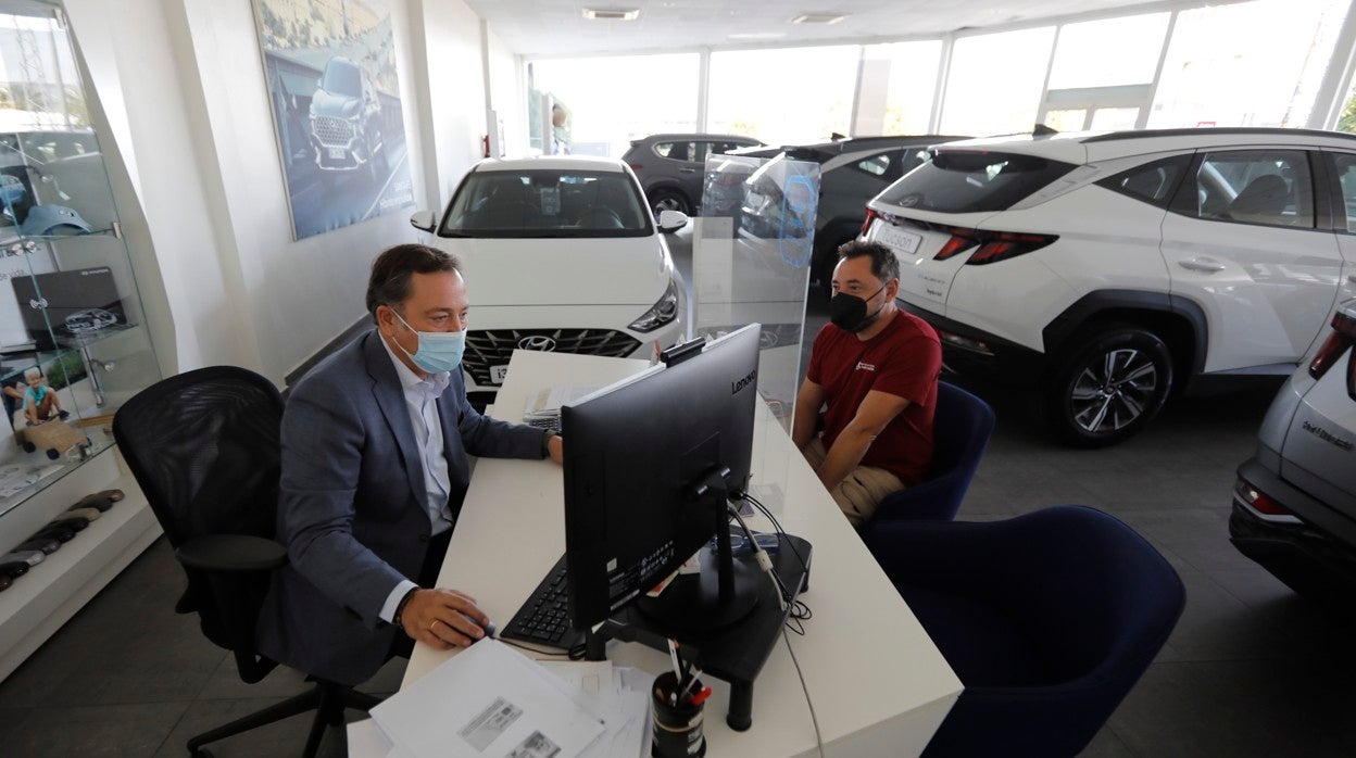 Un vendedor atiende a un cliente en un concesionario de coches