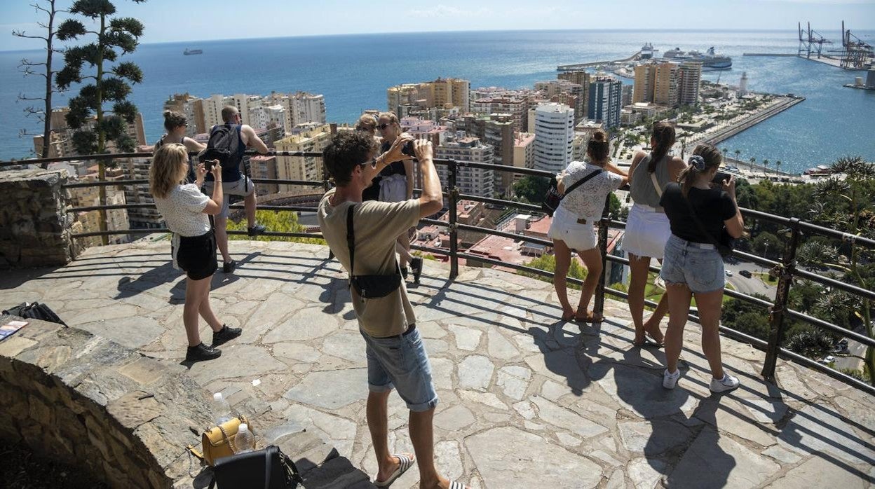 Un grupo de turistas contempla la llegada de cruceristas al puerto de Málaga