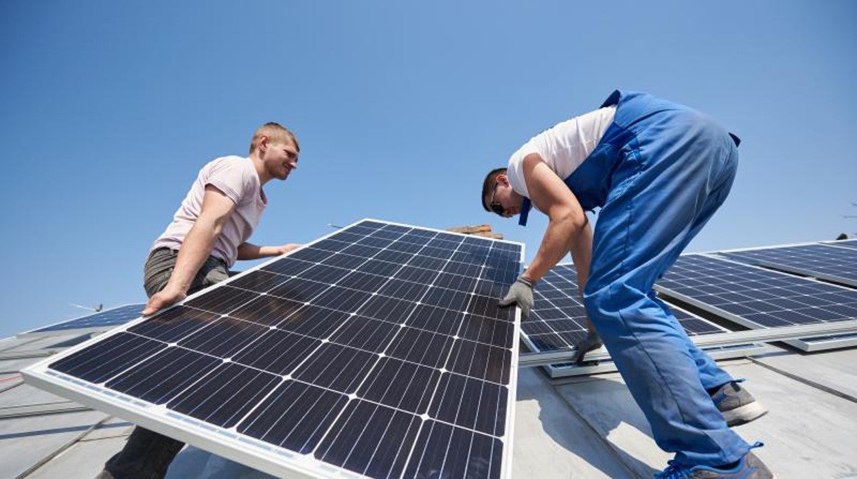 Dos trabajadores instalando paneles solares
