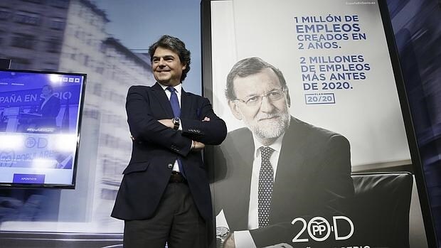 Jorge Moragas, director de la campaña del PP para el 20-D, junto a un cartel de Mariano Rajoy