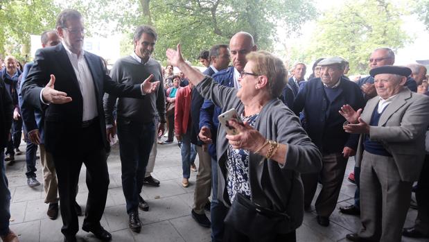 Una vecina de Arzúa saluda a Rajoy durante su paseo