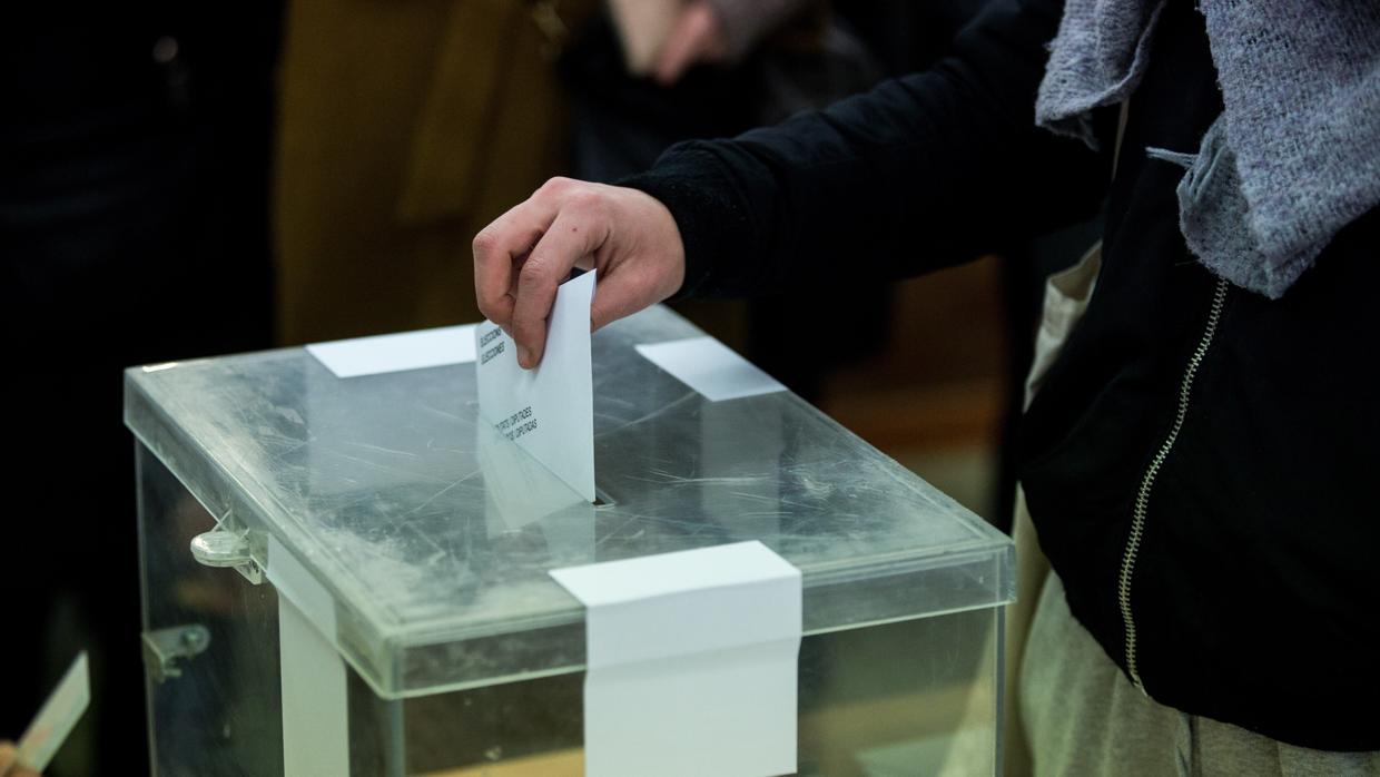 Un ciudadano deposita su voto en la urna del colegio electoral Narcís Monturió de Barcelona