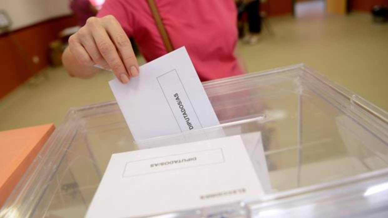 Imagen de archivo de una persona depositando su voto en las elecciones generales