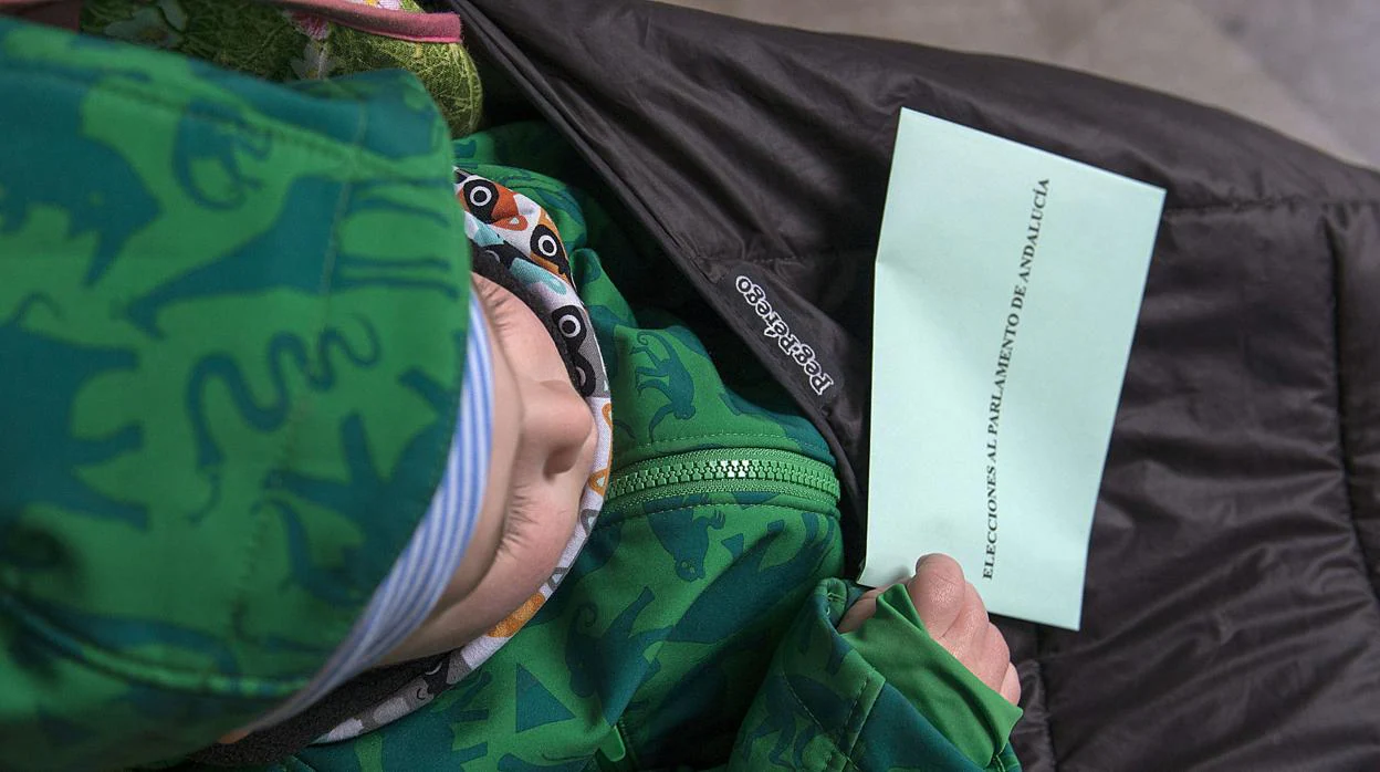 Un niño sostiene un sobre de las elecciones de Abdalucía 2015
