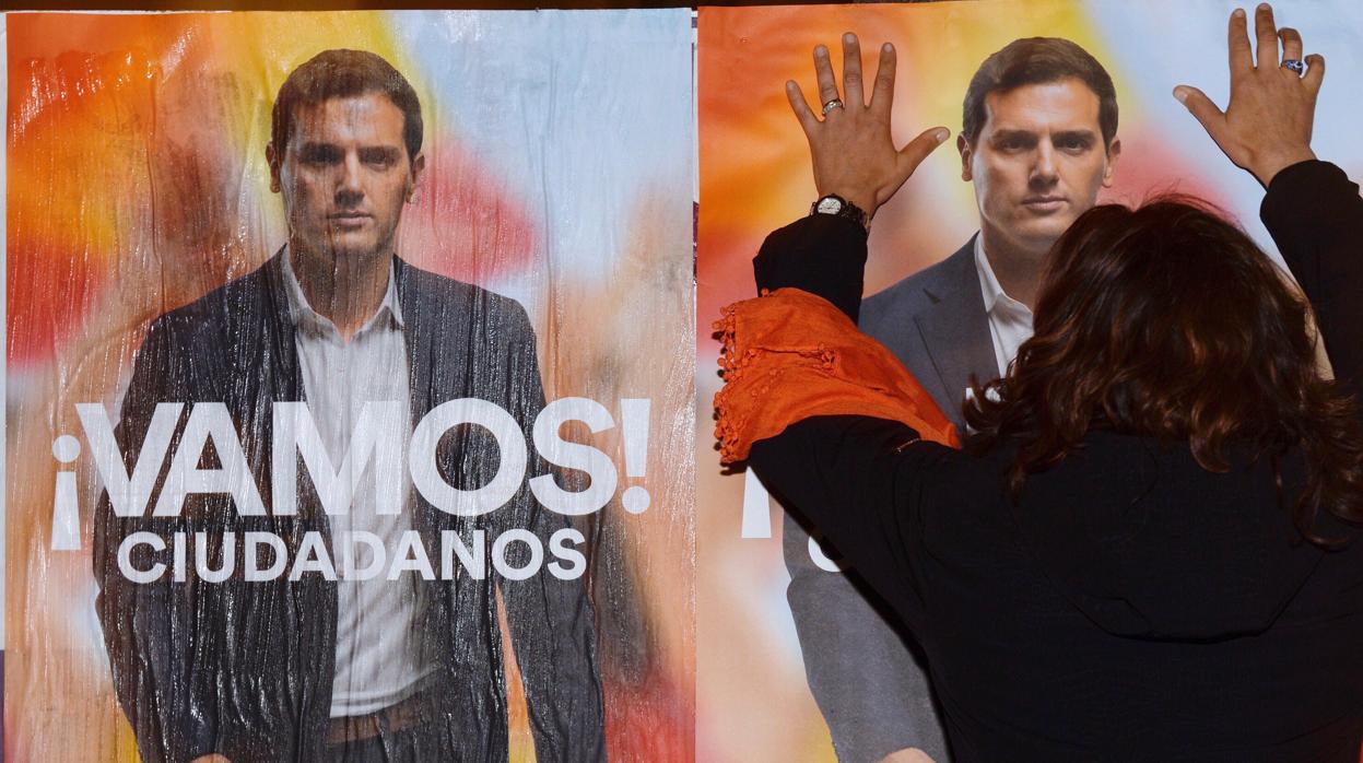 Una simpatizante de Ciudadanos pega carteles electorales en Valladolid